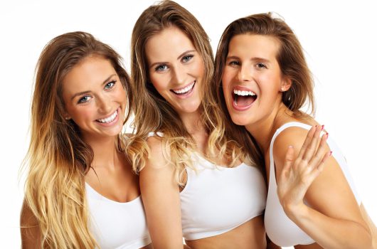 Group of happy friends in underwear over white background